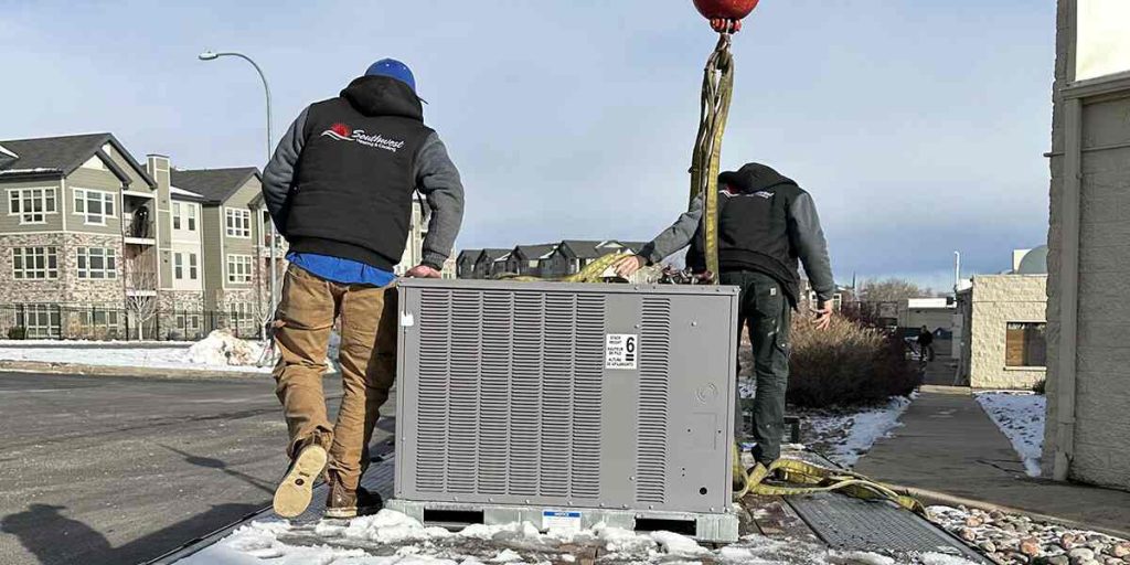 Technicians from Southwest Heating & Cooling installing a rooftop HVAC unit