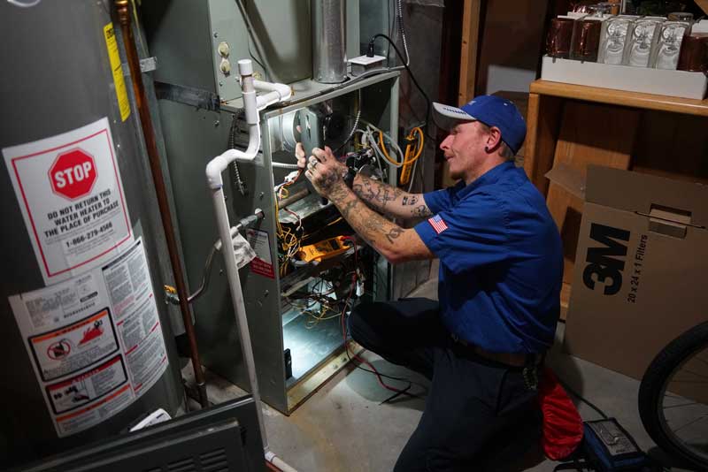 HVAC technician repairing a furnace in a residential basement