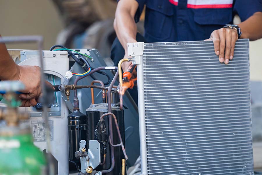 Technicians repairing HVAC unit