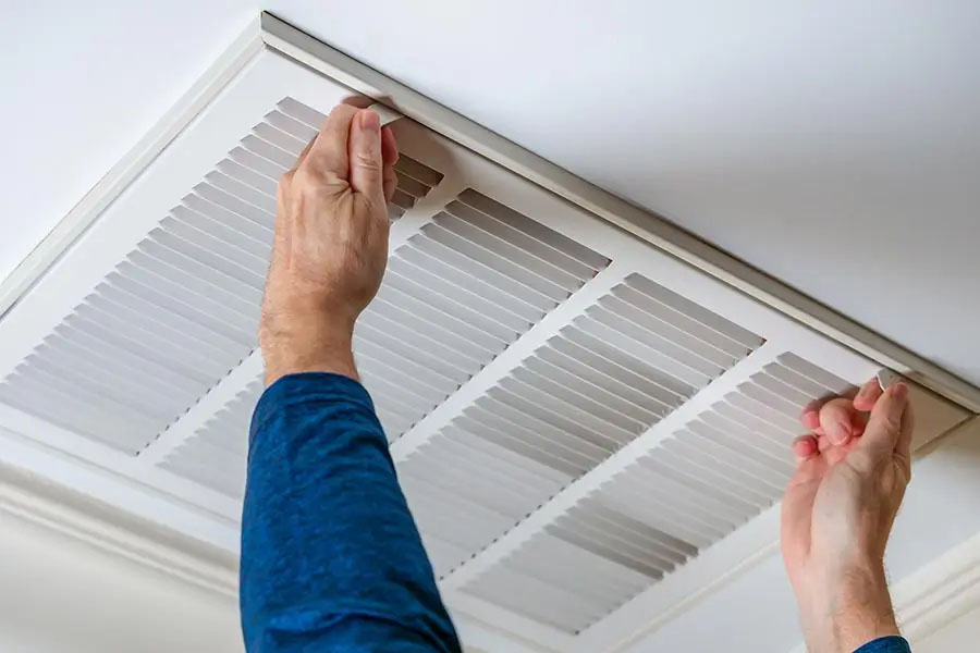 Person removing ceiling air vent